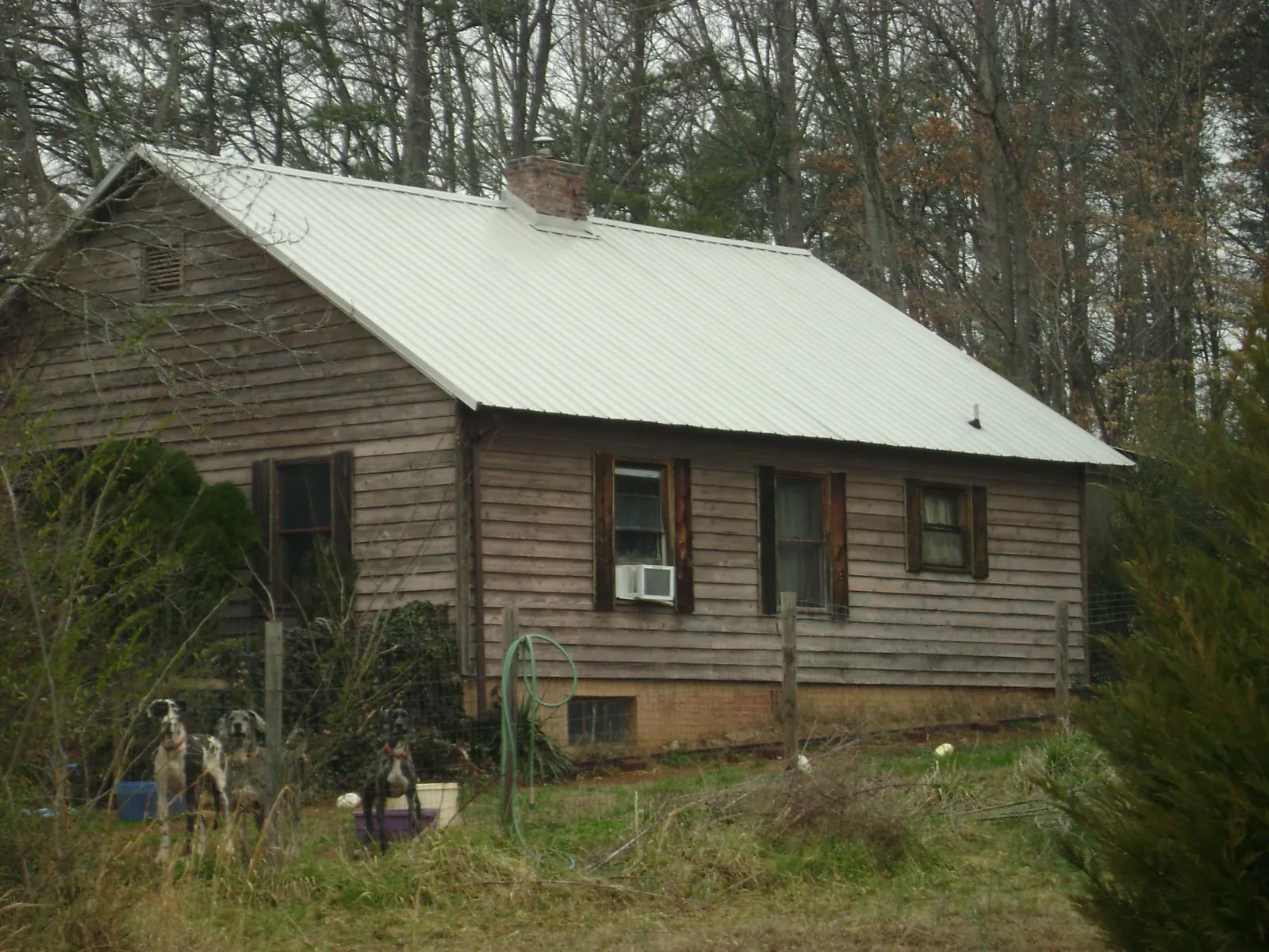 White metal roof on an old wood sided farmhouse, from a Metal Roof Installation job in Renner
